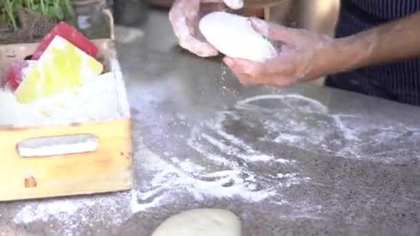 Chefs hands close-up. Prepares the dough for pizza, rolls out in round shapes with his hands. - Séquence, vidéo