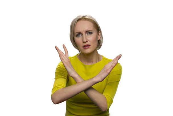 Femme avec le visage suppliant faisant signe x avec les mains croisées sur fond blanc. - Photo, image