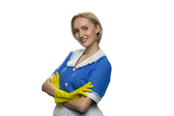 Smiling blonde maid in yellow rubber gloves with crossed arms on white background. - Photo, Image