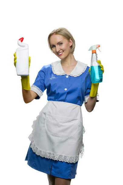Smiling maid holding in hand cleaner spray and toilet disinfectant raising hands up on white background. - Zdjęcie, obraz