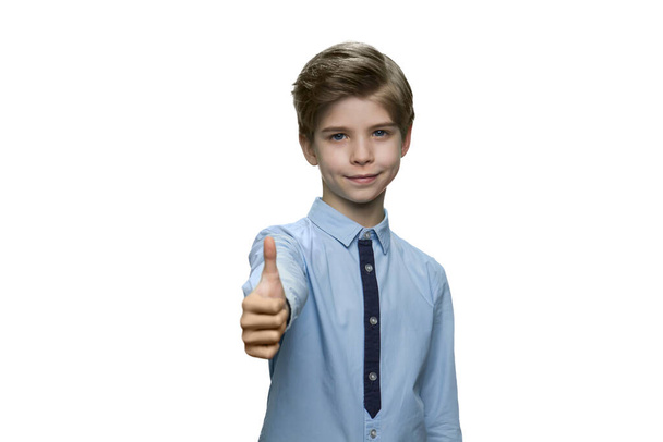 Chłopiec w niebieskiej koszuli pokazuje znak OK z kciukiem w górze. - Zdjęcie, obraz