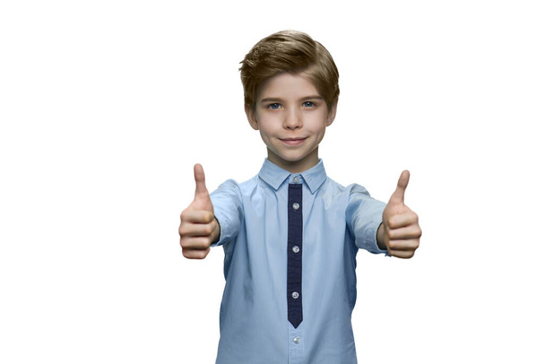 Junge im blauen Hemd zeigt Okay mit beiden Händen auf weißem Hintergrund. - Foto, Bild