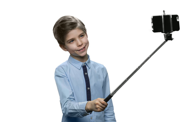 Feliz niño tomando selfie usando un palo
. - Foto, imagen