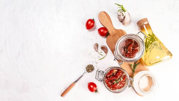 Sun dried tomatoes with fresh herbs and spices. Delicious snack on wooden textured background, top view. space for text. Long banner format. - Photo, Image