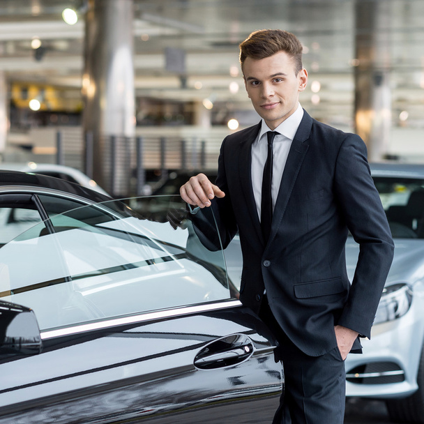 Man in formalwear leaning at the car door - Photo, Image