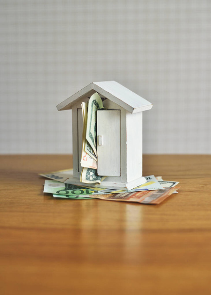 Rahaa ja talon malli pöydälle. käsite aiheesta rakentaminen ja rahaa - Valokuva, kuva
