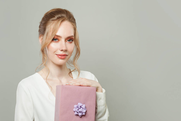 Fashion portrait of beautiful woman with gift on white background - Фото, зображення