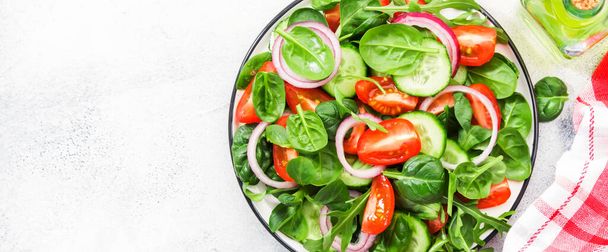 Spring vegan salad with cherry tomatoes, corn salad, baby spinach, cucumber and red onion. Healthy food concept. Panoramic banner with copy space - Foto, afbeelding