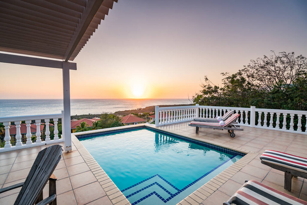 Coucher de soleil au bord de la belle piscine de luxe  - Photo, image