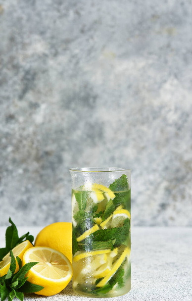 Lemonade with syrup and mint in a glass cup on a concrete background. - 写真・画像
