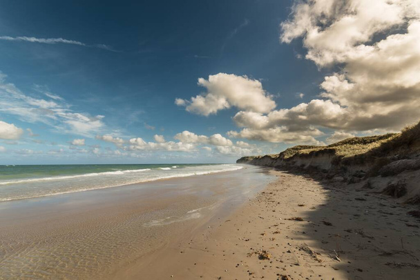Zachwycające ujęcie spokojnej plaży pod błękitnym niebem - Zdjęcie, obraz