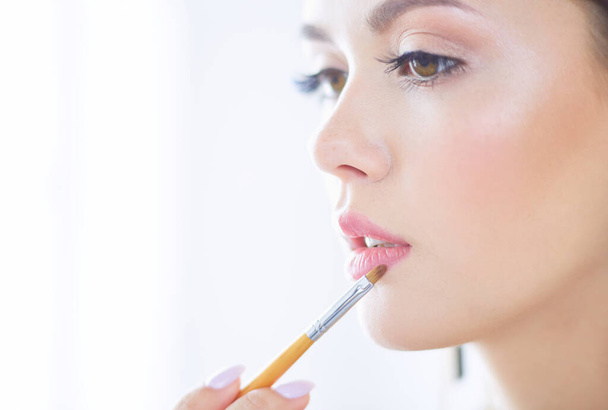 Beautiful girl with cosmetic powder brush for make up. Makeup. Make-up applying for perfect skin - 写真・画像