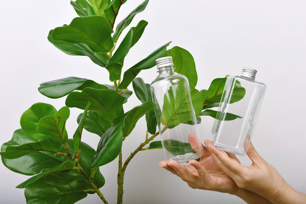 Botella de cuidado de la piel natural de mano, Envases de botellas cosméticas con esencia de planta verde pura, Concepto de producto de belleza orgánica
. - Foto, imagen