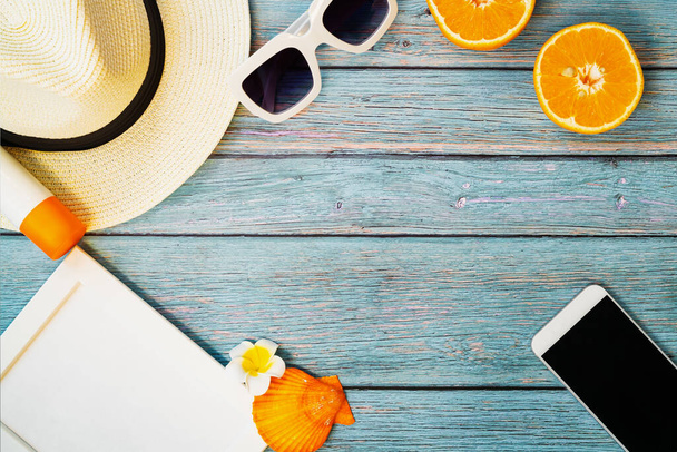 美しい夏休み、ビーチアクセサリー、オレンジ、サングラス、帽子、木製の背景にサンブロックスマートフォン - 写真・画像