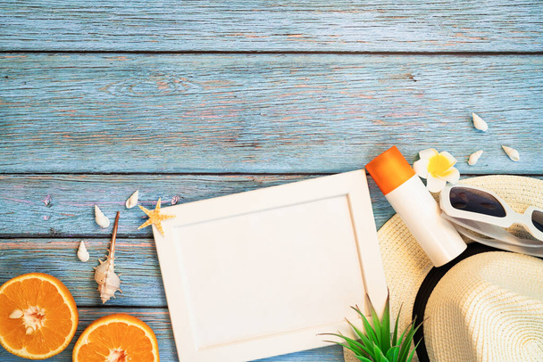 Mooie zomervakantie, strandaccessoires, oranje, zonnebril, hoed en zonnebrandcrème op houten achtergronden - Foto, afbeelding