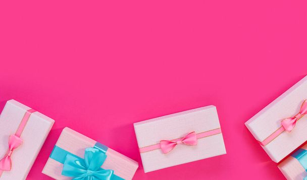 Set of beautiful gift boxes with blue bows on pink background. Holiday sale - Photo, image
