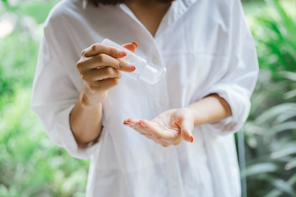 женщина с помощью спирта антисептический гель для очистки руки - Фото, изображение