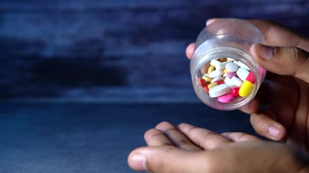 Detailní záběr muže ruku brát nadměrné pilulky z kontejneru  - Záběry, video