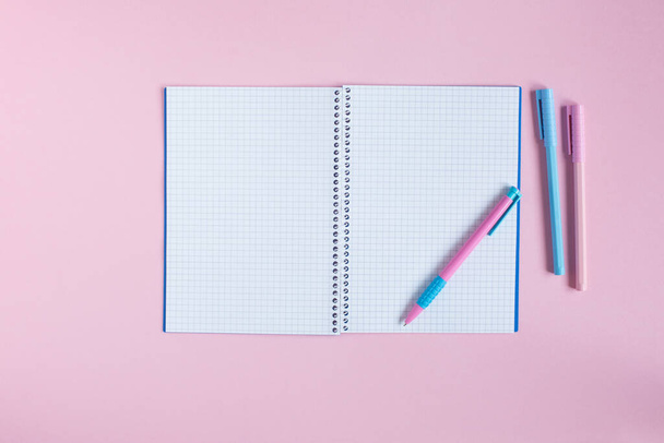 Cuaderno escolar y papelería sobre fondo rosa. Regreso al concepto escolar - Foto, Imagen