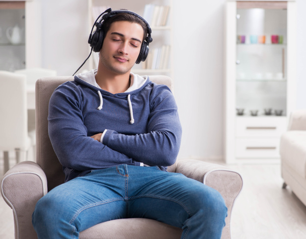 Молодий чоловік слухає музику вдома
 - Фото, зображення