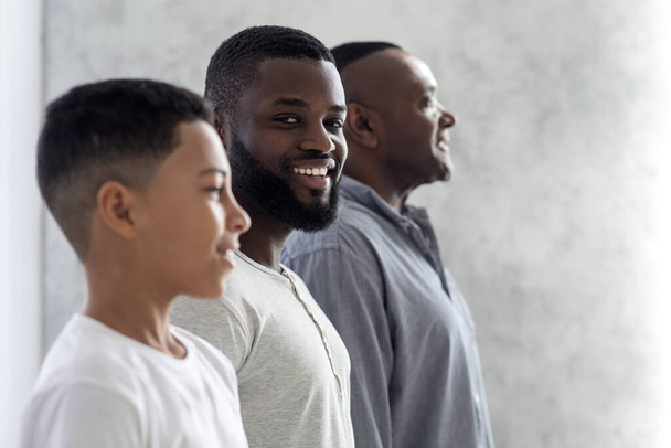 Férfiak szerepe a családban. Fekete ember pózol fiával és apjával - Fotó, kép