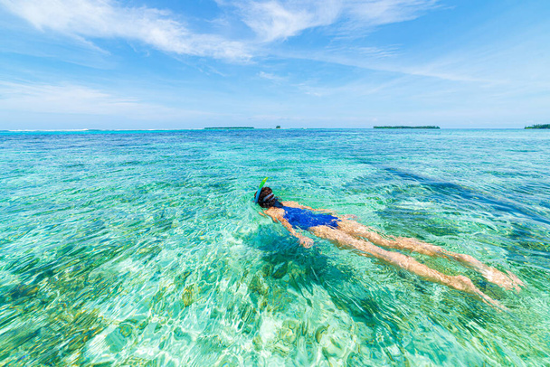 Woman snorkeling in caribbean on coral reef tropical turquoise blue water. Indonesia Wakatobi archipelago, marine national park, tourist diving travel destination - Photo, Image