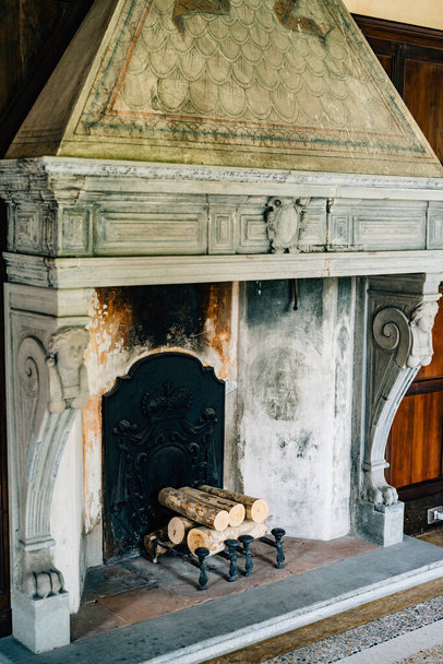 Стара пожежна коробка в будинку крупним планом. Старовинний камін в будинку з колонами і барельєфами
. - Фото, зображення