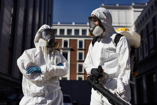two disinfectors with disinfectant in the streets - Foto, Imagem