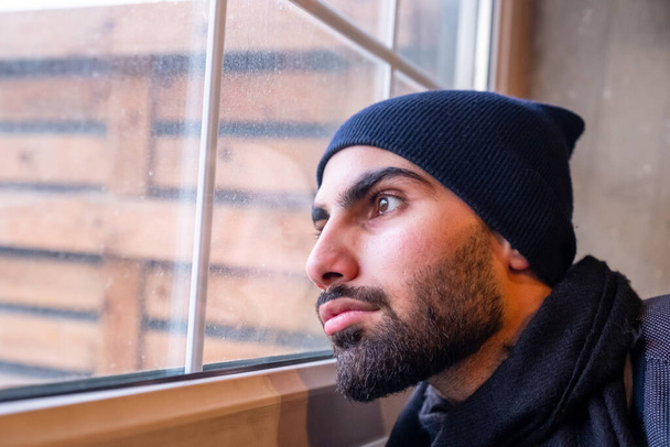 Arap Müslüman adam, pencereden üzgün bakıyor. - Fotoğraf, Görsel