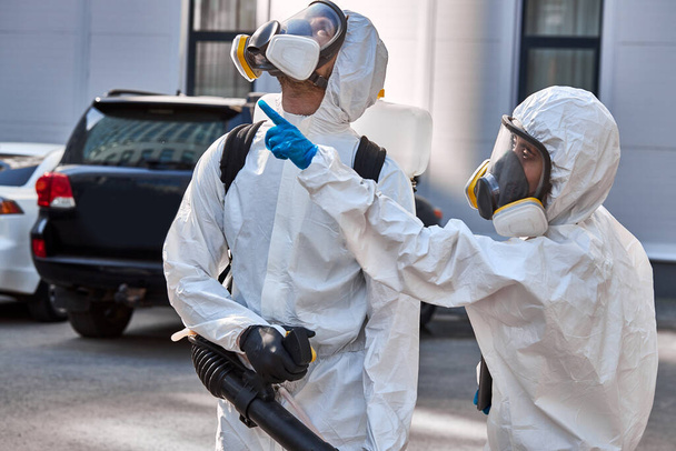 coronavirus pandemic. disinfectors in protective suits enclosing the quarantine zone - Foto, immagini