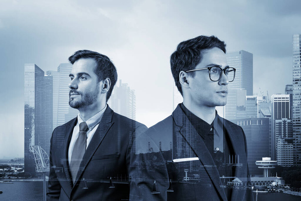 Two young handsome businessman in suits dreaming about new career opportunities after MBA graduation. Teamwork concept. Singapore on background. Double exposure. - Zdjęcie, obraz