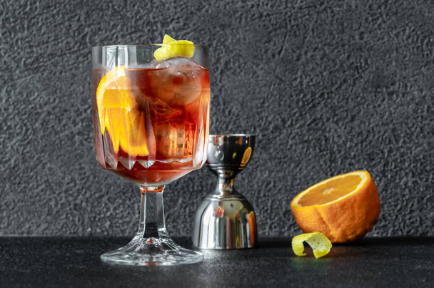 Glas Americano cocktail gegarneerd met sinaasappelschijfje en citroenschil - Foto, afbeelding