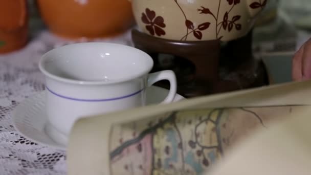 schot van kopjes thee en een pot op tafel - Video
