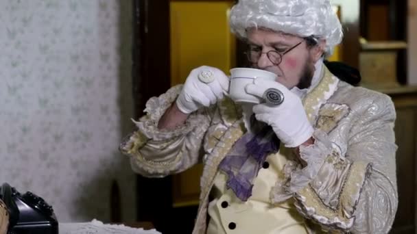 άνθρωπος με μια λευκή περούκα πίνοντας ένα φλιτζάνι του τσαγιού - Πλάνα, βίντεο