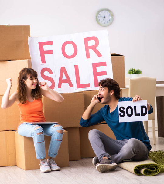 Genç bir aile satılık ev teklif ediyor ve taşınıyor. - Fotoğraf, Görsel