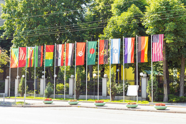 Государственные флаги разных стран на флагштоке подряд машут на ветру. Концепция дипломатии, международные отношения - Фото, изображение