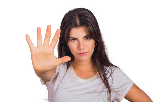 Retrato de mujer joven mostrando gesto de alto con la palma de la mano. Fondo blanco aislado
. - Foto, Imagen