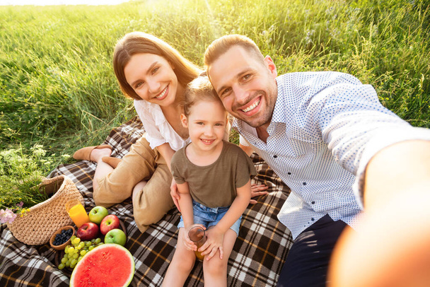 Happy family taking selfie in the countryside on sunny day - Photo, Image