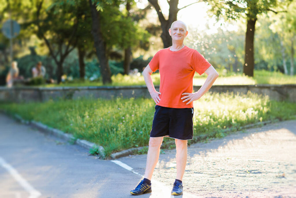 Portrait of a happy active senior man posing after exercising outdoors - 写真・画像