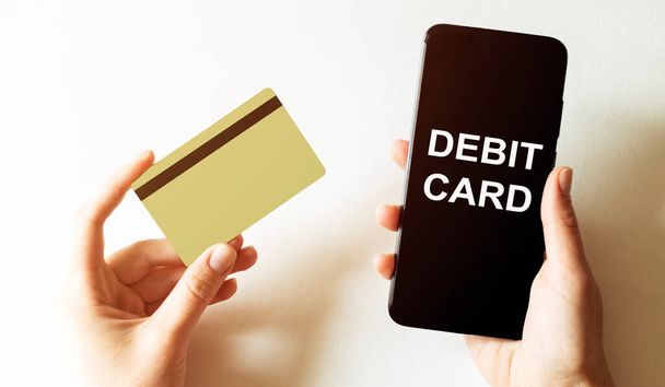 tarjeta de oro y teléfono con el desastre de texto recuperar el plan de tarjeta de débito en las manos femeninas
 - Foto, Imagen