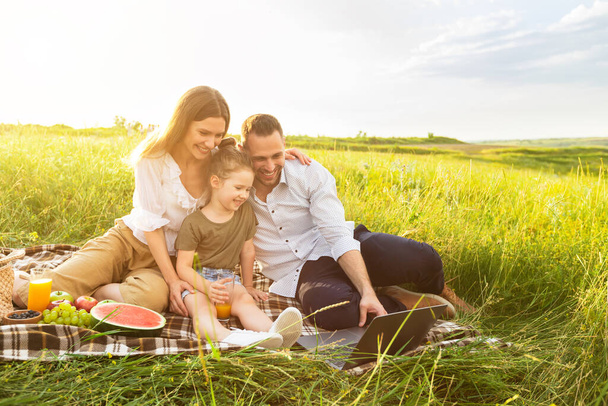 Szczęśliwa rodzina razem na pikniku z laptopem - Zdjęcie, obraz