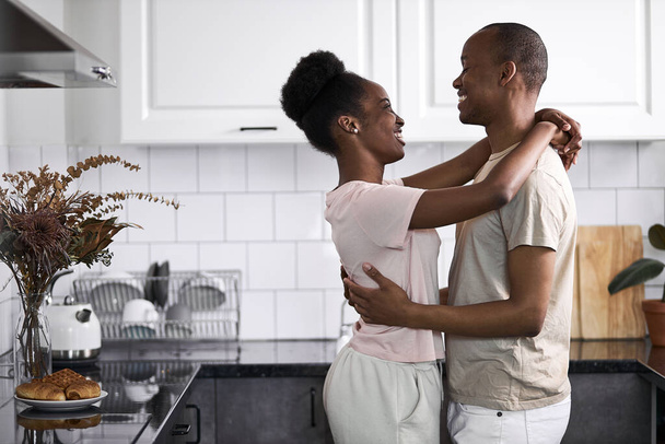 dark-skinned man and woman dancing in pajamas at home - Фото, изображение