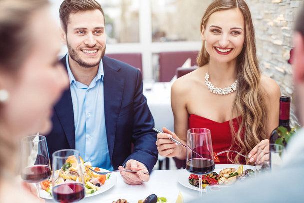 Dos parejas alegres charlando en un bonito restaurante
 - Foto, Imagen