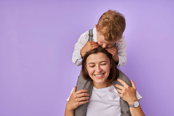 happy mother holds kid boy on her neck - Foto, Imagen