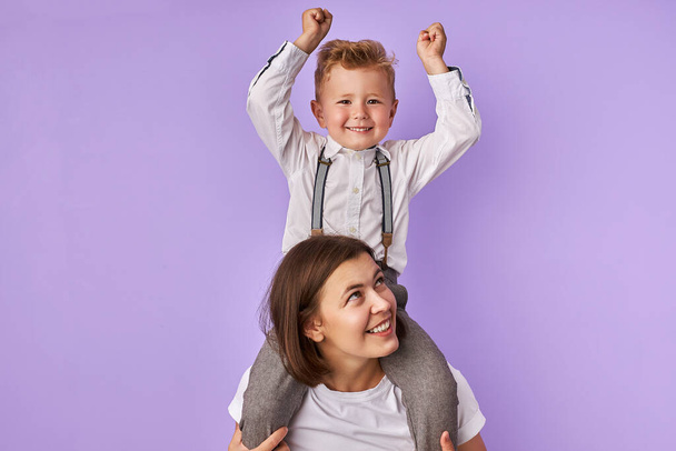 cute mother and kid boy isolated over purple background - Zdjęcie, obraz
