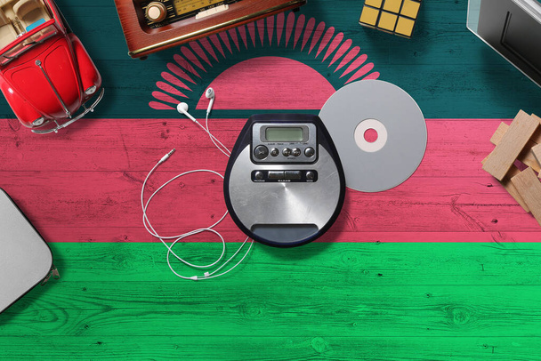 Malawi flag on wooden desk with retro digital media concept. National entertainment theme. - Fotó, kép