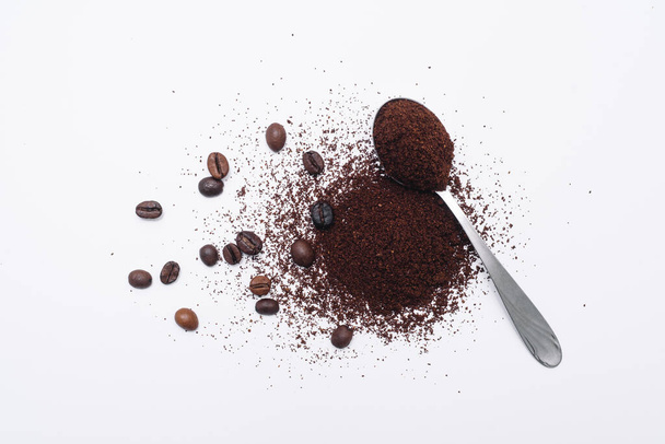 Grounded coffee in a spoon surrounded with beans isolated - Foto, Imagem