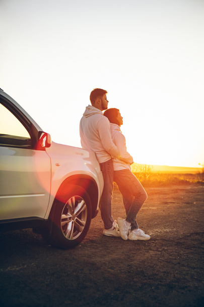 romantic moment couple looking on sunset near white suv car copy space. - Foto, Imagen