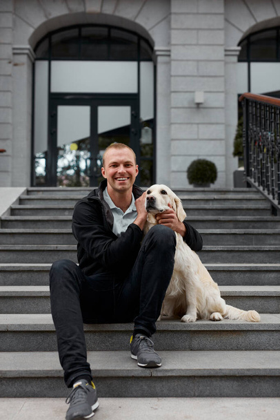 young man sit hugging golden retriever dog - Foto, immagini