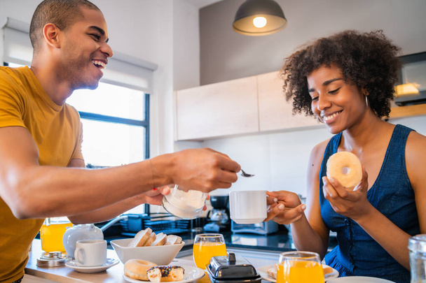 Portrait of happy young couple having breakfast together at home. Relationship and lifestyle concept. - Foto, immagini